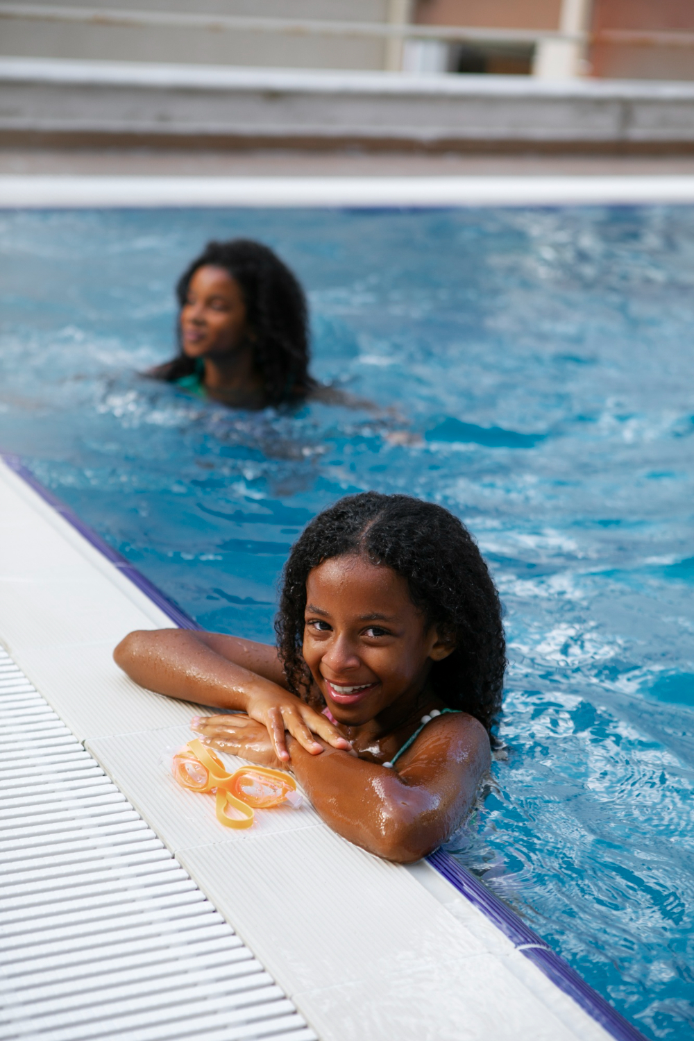 Swimmer resting at the edge of a supervised pool