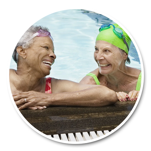 Two smiling senior women exercising in an outdoor pool